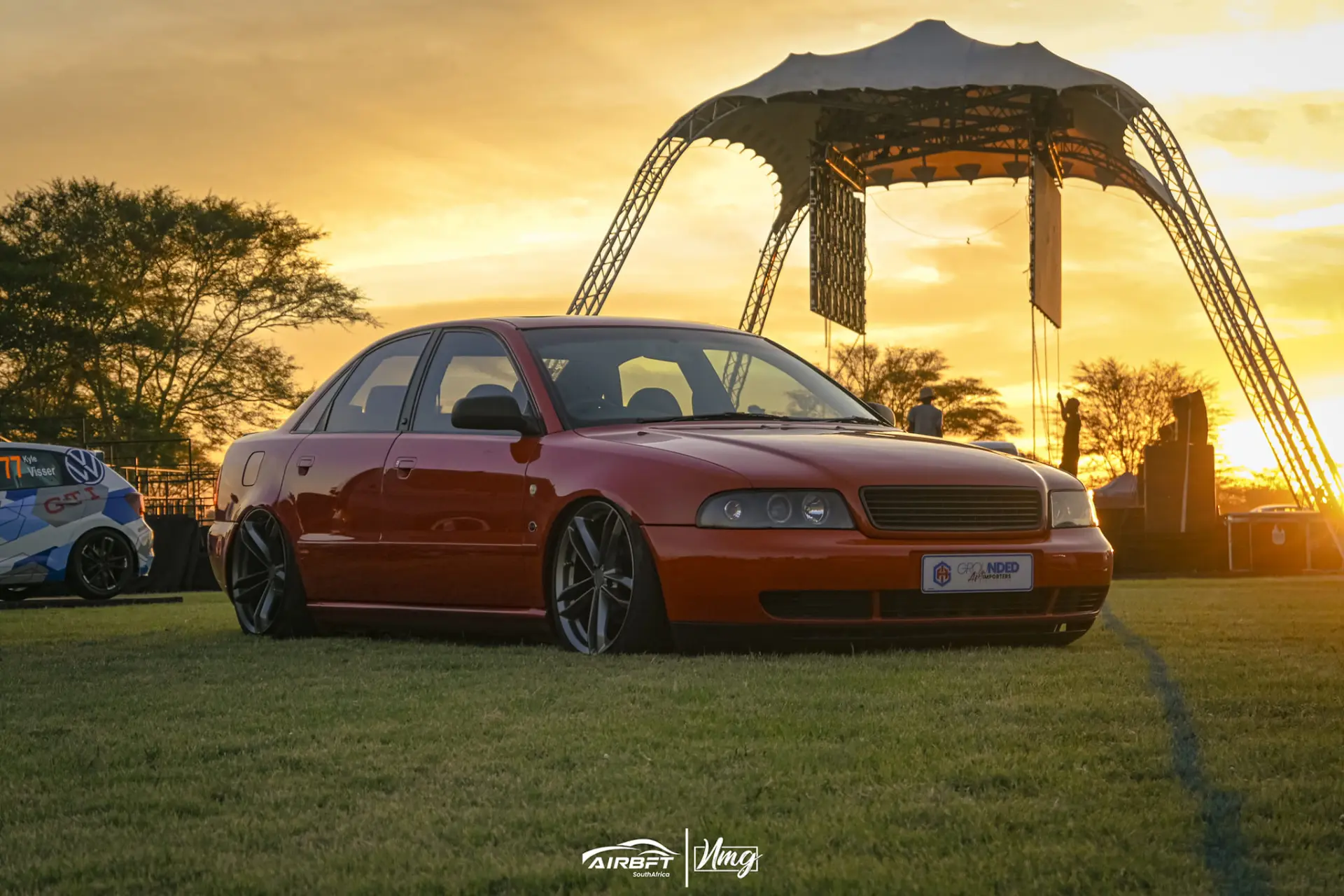 Lowered red Audi on AIRBFT air suspension at sunset